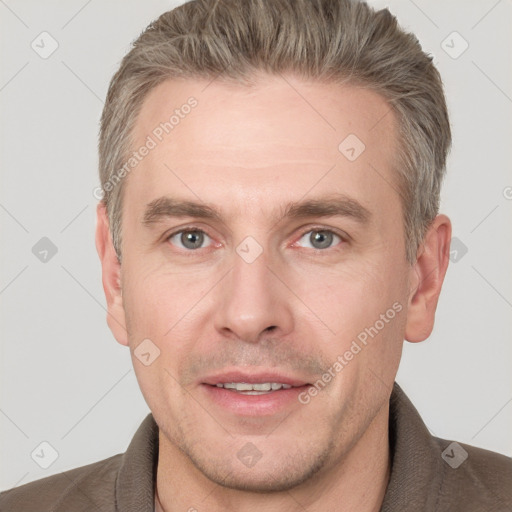 Joyful white adult male with short  brown hair and grey eyes