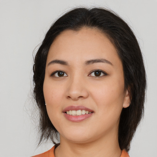 Joyful asian young-adult female with medium  brown hair and brown eyes