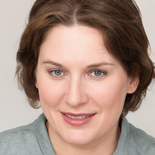 Joyful white young-adult female with medium  brown hair and blue eyes