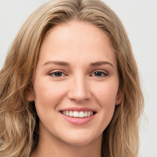 Joyful white young-adult female with long  brown hair and green eyes