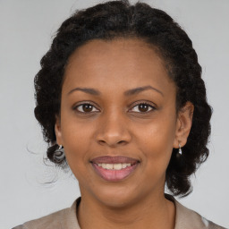 Joyful black adult female with medium  brown hair and brown eyes