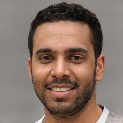 Joyful white young-adult male with short  black hair and brown eyes