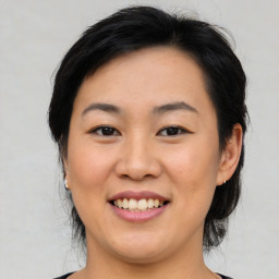 Joyful asian young-adult female with medium  black hair and brown eyes