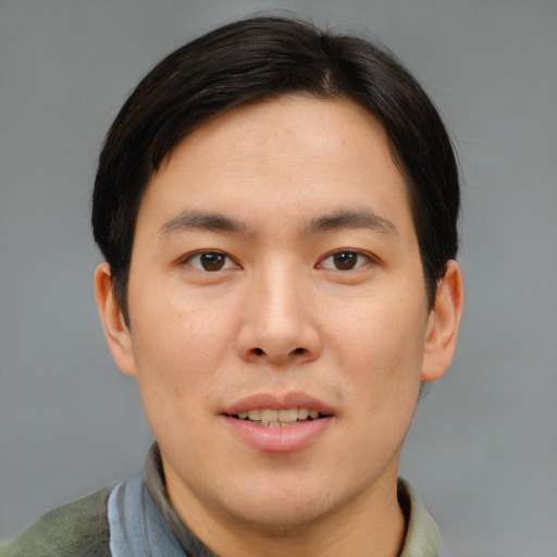 Joyful asian young-adult male with short  brown hair and brown eyes