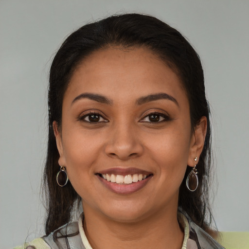 Joyful latino young-adult female with medium  brown hair and brown eyes