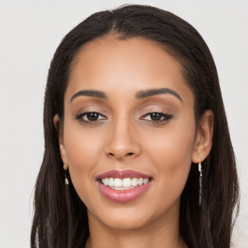 Joyful latino young-adult female with long  brown hair and brown eyes