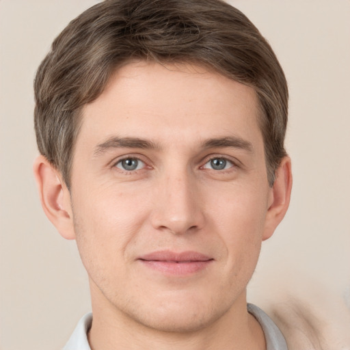 Joyful white young-adult male with short  brown hair and grey eyes