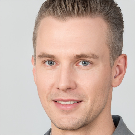 Joyful white adult male with short  brown hair and grey eyes