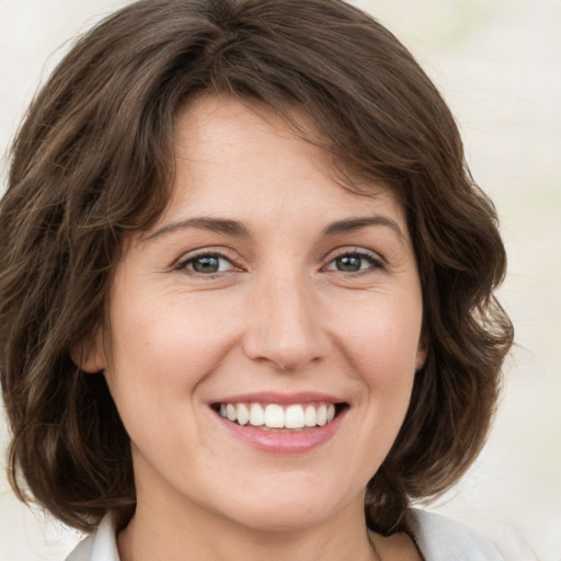 Joyful white young-adult female with medium  brown hair and green eyes