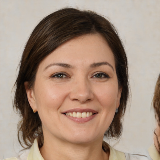 Joyful white young-adult female with medium  brown hair and brown eyes