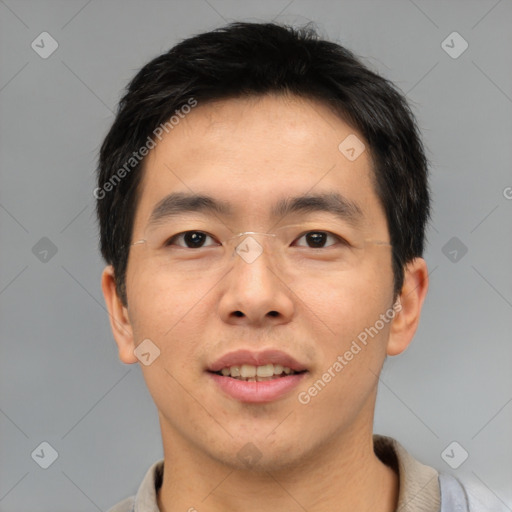 Joyful asian young-adult male with short  brown hair and brown eyes