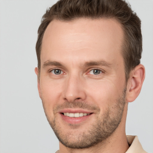 Joyful white young-adult male with short  brown hair and grey eyes