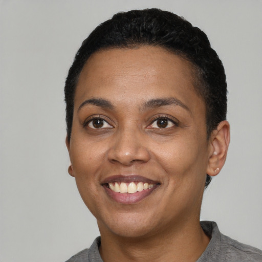 Joyful black young-adult female with short  black hair and brown eyes