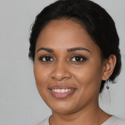Joyful black young-adult female with medium  black hair and brown eyes