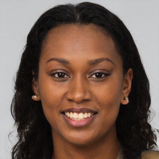 Joyful black young-adult female with long  brown hair and brown eyes
