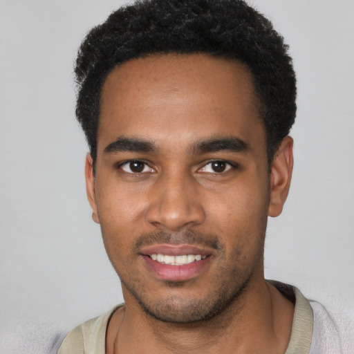 Joyful black young-adult male with short  black hair and brown eyes