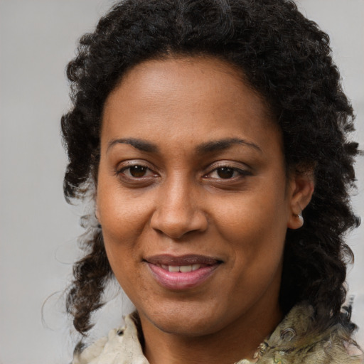 Joyful black adult female with medium  brown hair and brown eyes