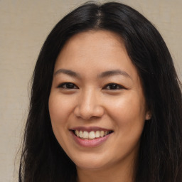 Joyful asian young-adult female with long  brown hair and brown eyes