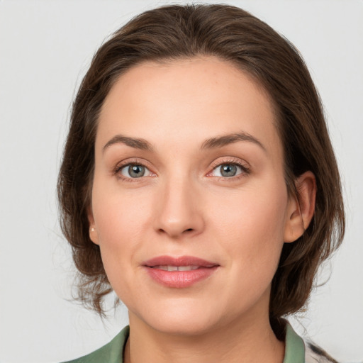 Joyful white young-adult female with medium  brown hair and green eyes