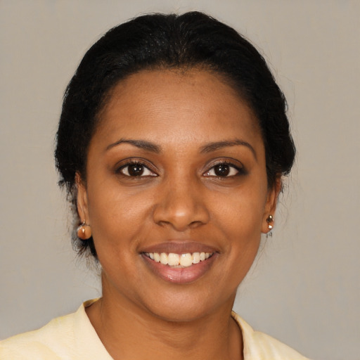 Joyful black young-adult female with medium  brown hair and brown eyes