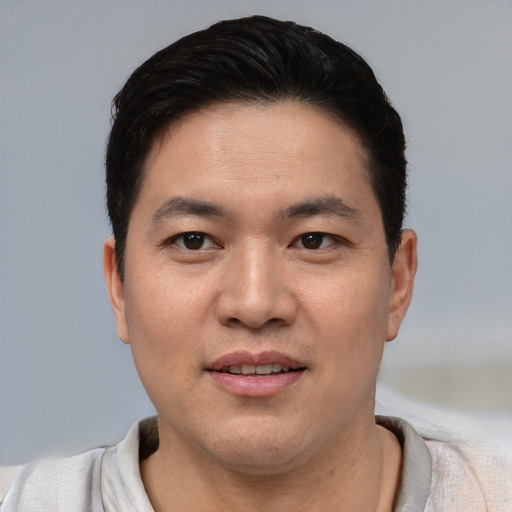 Joyful asian young-adult male with short  black hair and brown eyes