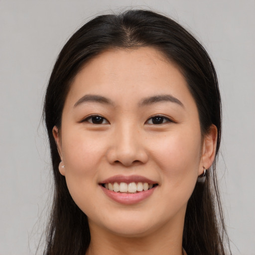 Joyful asian young-adult female with long  brown hair and brown eyes