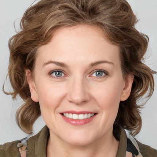 Joyful white young-adult female with medium  brown hair and blue eyes