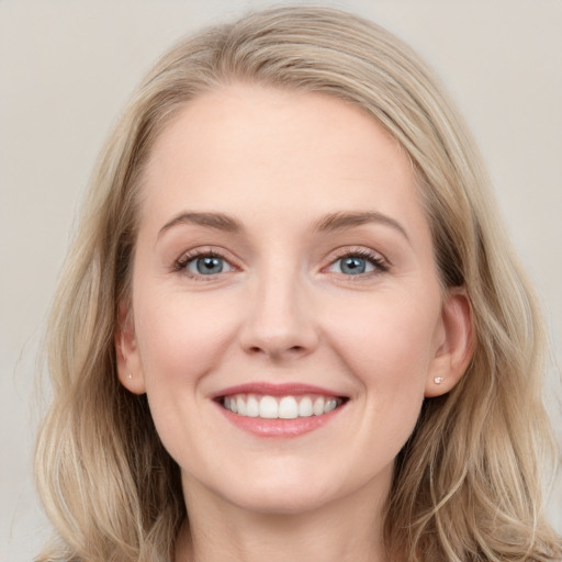 Joyful white young-adult female with long  brown hair and blue eyes