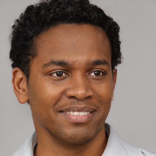 Joyful black young-adult male with short  brown hair and brown eyes