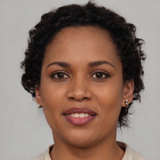 Joyful black young-adult female with short  brown hair and brown eyes