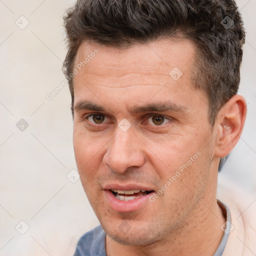 Joyful white adult male with short  brown hair and brown eyes