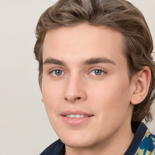 Joyful white young-adult male with medium  brown hair and grey eyes