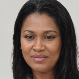 Joyful black young-adult female with long  brown hair and brown eyes