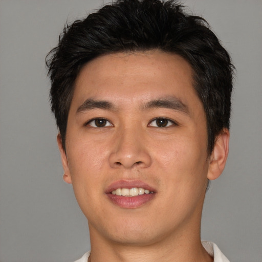 Joyful asian young-adult male with short  brown hair and brown eyes