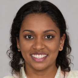 Joyful black young-adult female with medium  brown hair and brown eyes