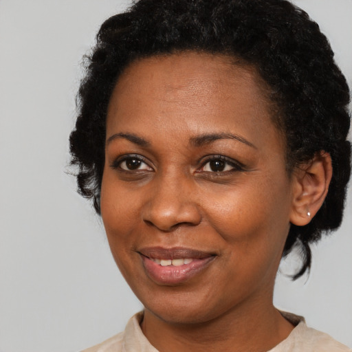 Joyful black adult female with short  black hair and brown eyes