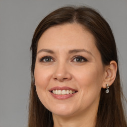 Joyful white adult female with long  brown hair and brown eyes