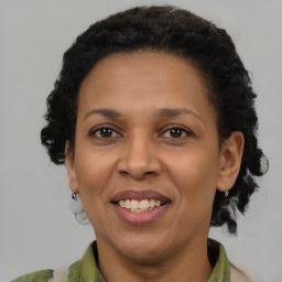 Joyful black adult female with medium  brown hair and brown eyes