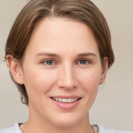 Joyful white young-adult female with medium  brown hair and grey eyes