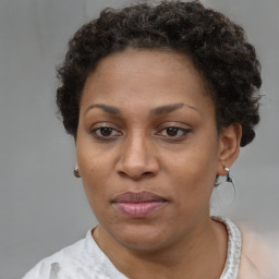 Joyful black adult female with short  brown hair and brown eyes