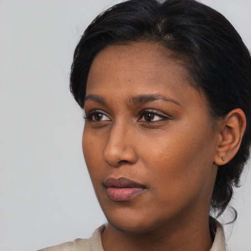 Neutral black young-adult female with medium  brown hair and brown eyes