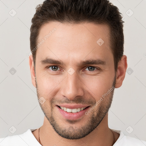 Joyful white young-adult male with short  brown hair and brown eyes