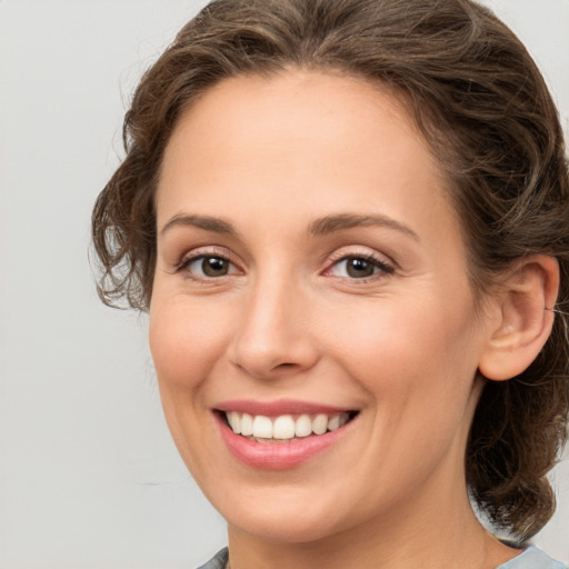 Joyful white young-adult female with medium  brown hair and grey eyes