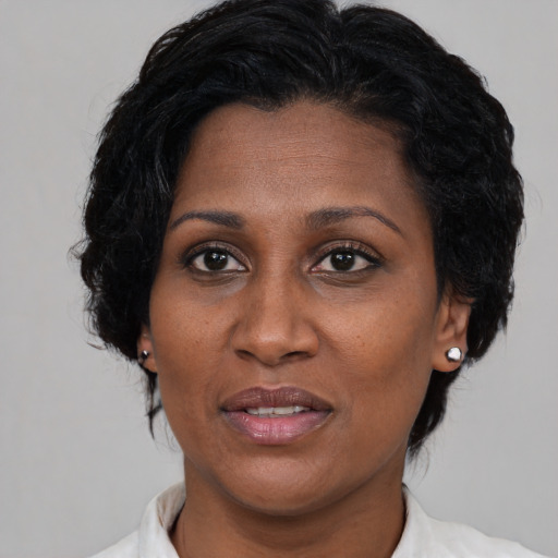 Joyful black adult female with medium  brown hair and brown eyes