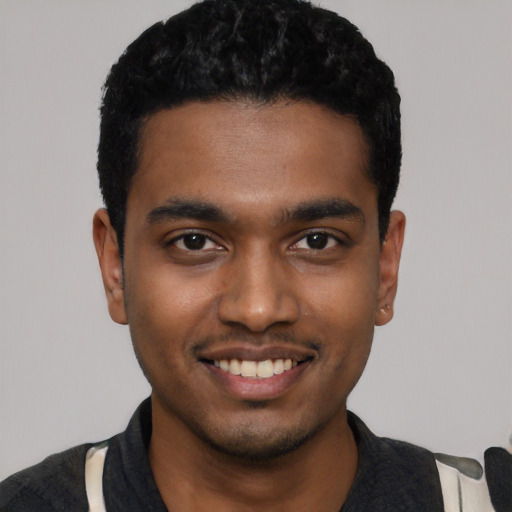 Joyful black young-adult male with short  black hair and brown eyes