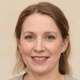 Joyful white adult female with medium  brown hair and grey eyes