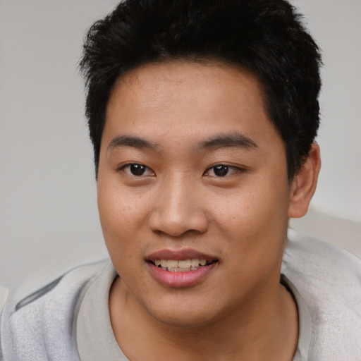 Joyful asian young-adult male with short  black hair and brown eyes
