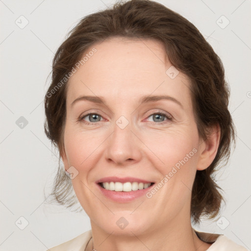 Joyful white young-adult female with medium  brown hair and green eyes