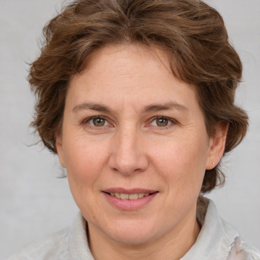 Joyful white adult female with medium  brown hair and green eyes