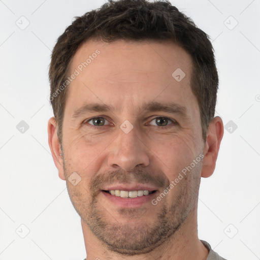 Joyful white adult male with short  brown hair and brown eyes